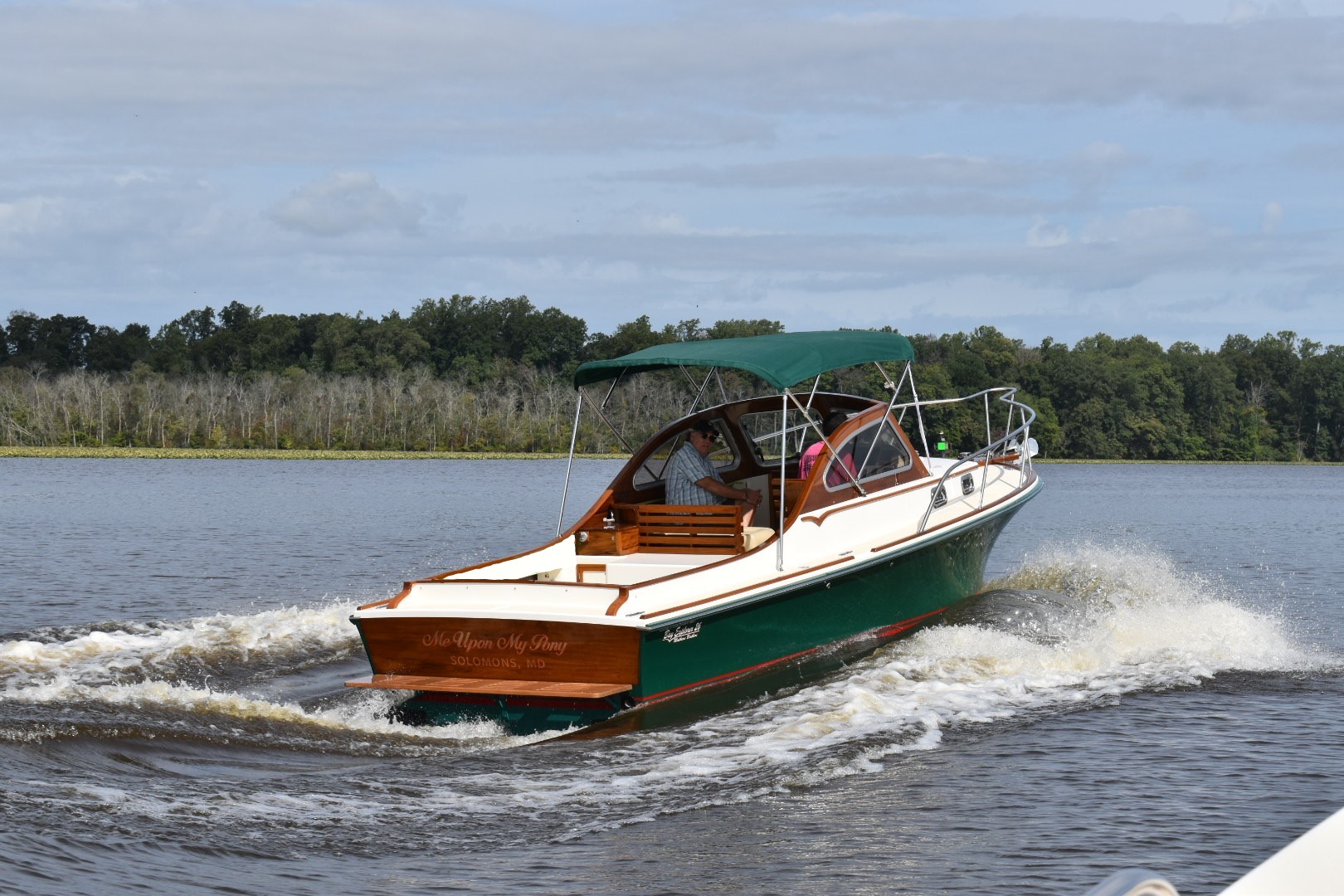 A green boat with a cockpit seating