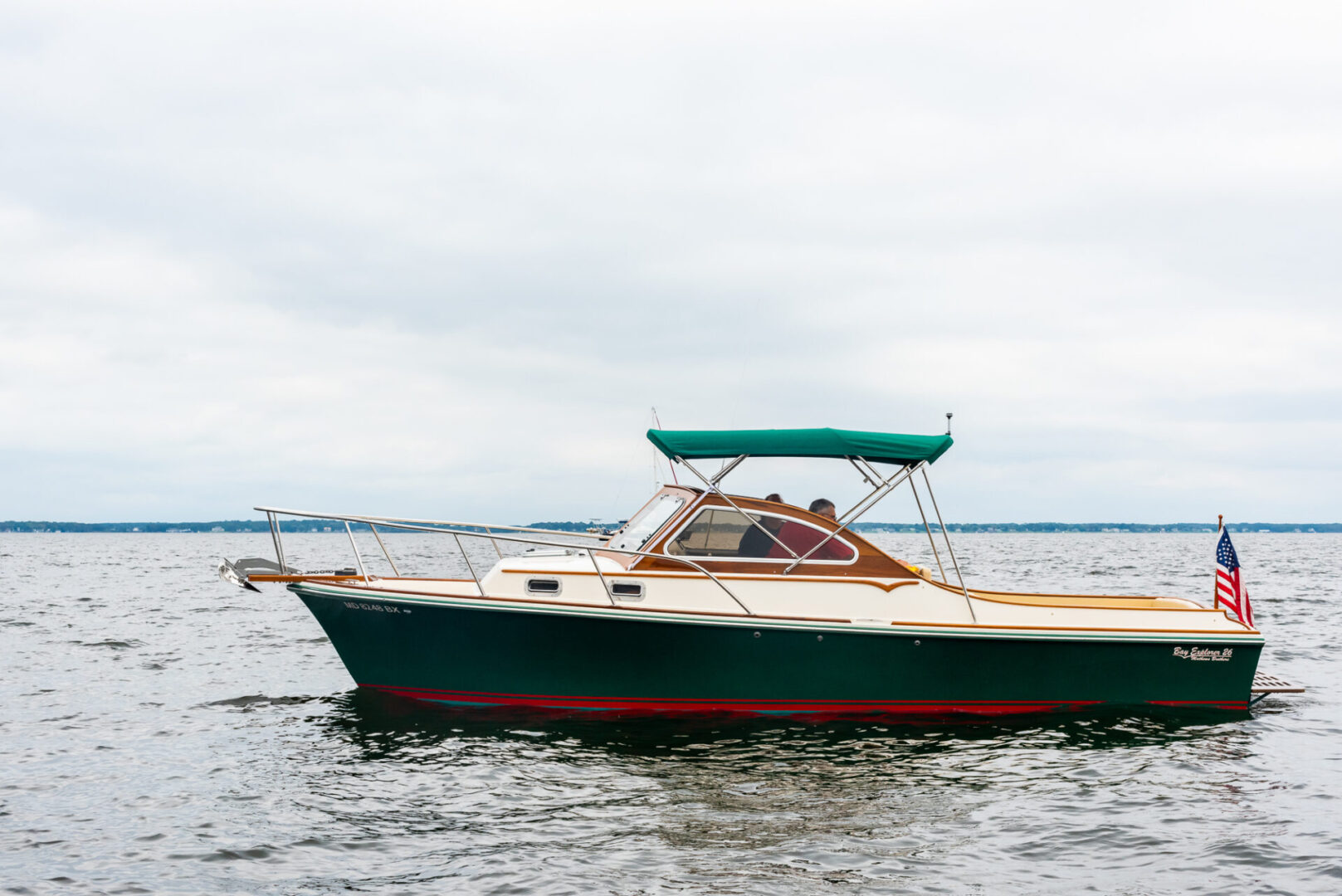 A Boat With Green Paint and an American Flag in Water